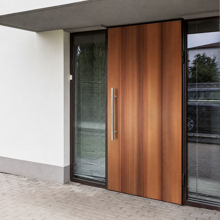 A satin round door handle installed in a brown door