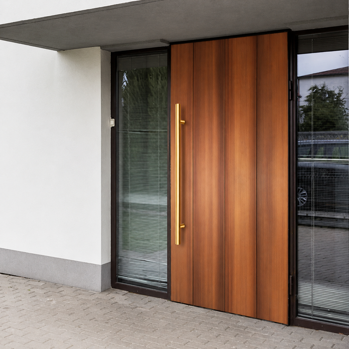 A gold round door handle installed in a brown door