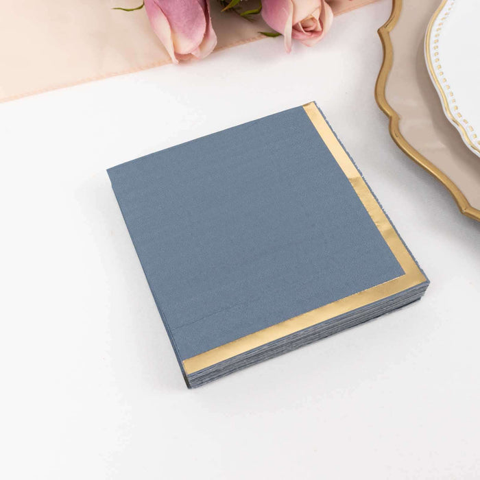 Elegant navy blue napkins with gold trim on a plain backdrop.
