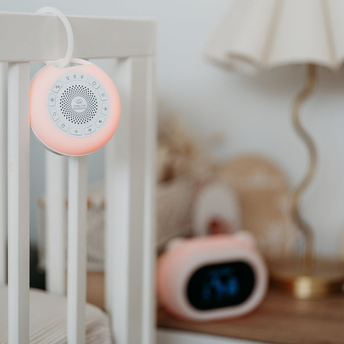 Sound Sleeper portable white noise with Sleep Like Goldilocks smart thermometer in background, both with red light
